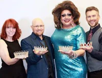 four people posing with crowns in front of a white background