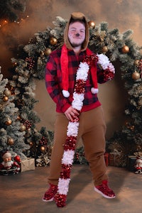 a man holding a candy cane in front of a christmas tree