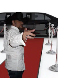 a man standing on a red carpet next to a black limo